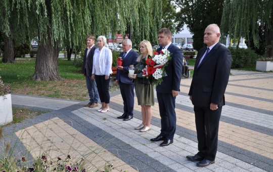 Na zdjęciu głównym przedstawiciele władz samorządowych stoją ustawieni w rzędzie przed pomnikiem imienia plutonowego Bolesława Bierwiaczonka.