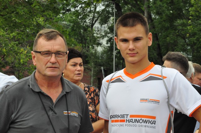 Zdjęcie przedstawia zawodnika z trenerem w klubowych koszulkach z logiem Parkiet Hajnówka